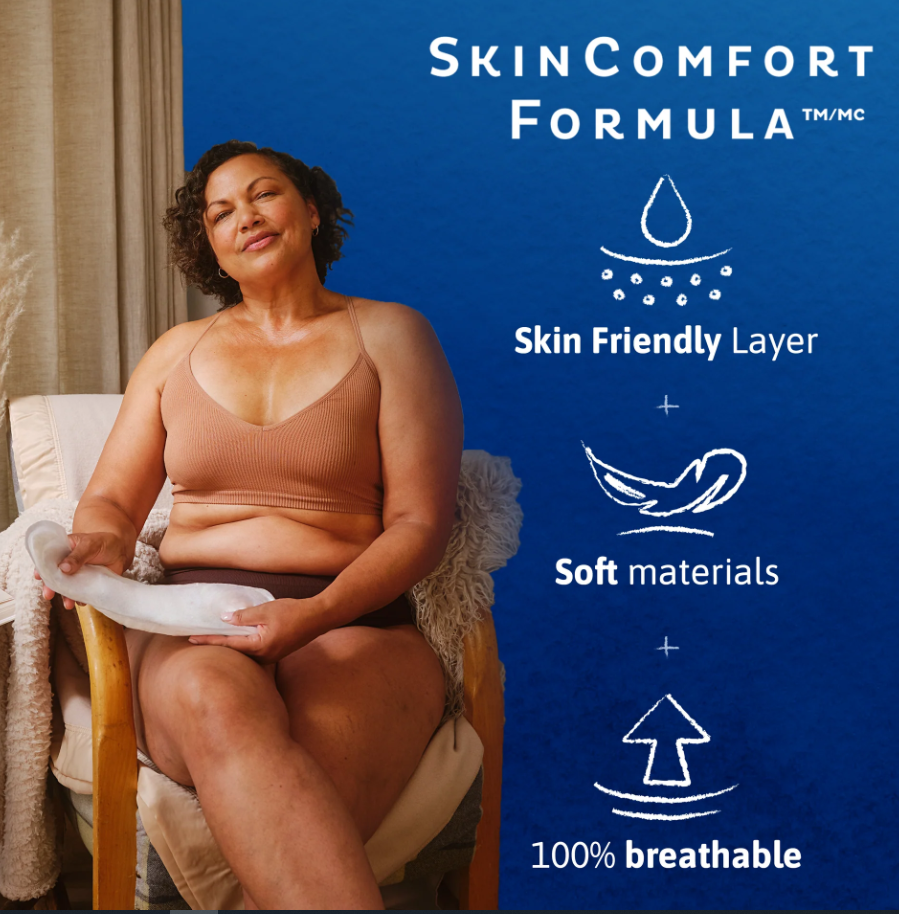 A woman sits in a chair holding a white absorbent pad, with a blue promotional graphic on the right reading 'SkinComfort Formula/MC' and feature icons for skin-friendly layer, soft materials, and 100% breathable.